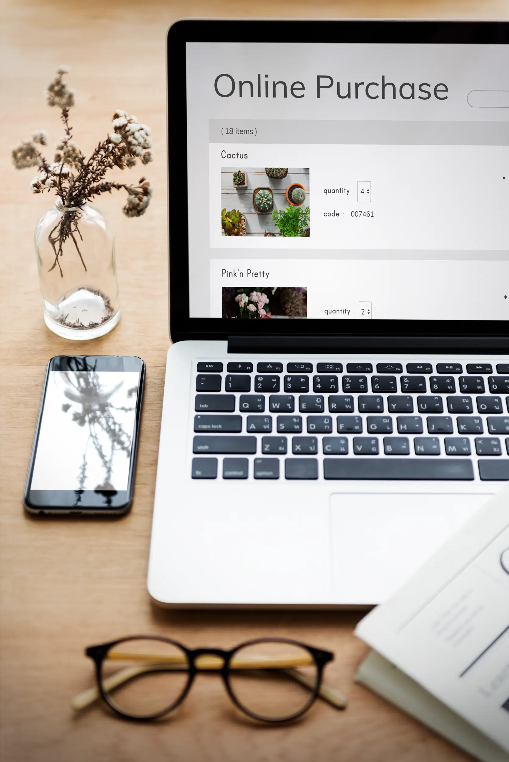Laptop showing an online purchase cart with product quantities, next to a smartphone